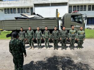 a group of men in uniform standing in front of a truck